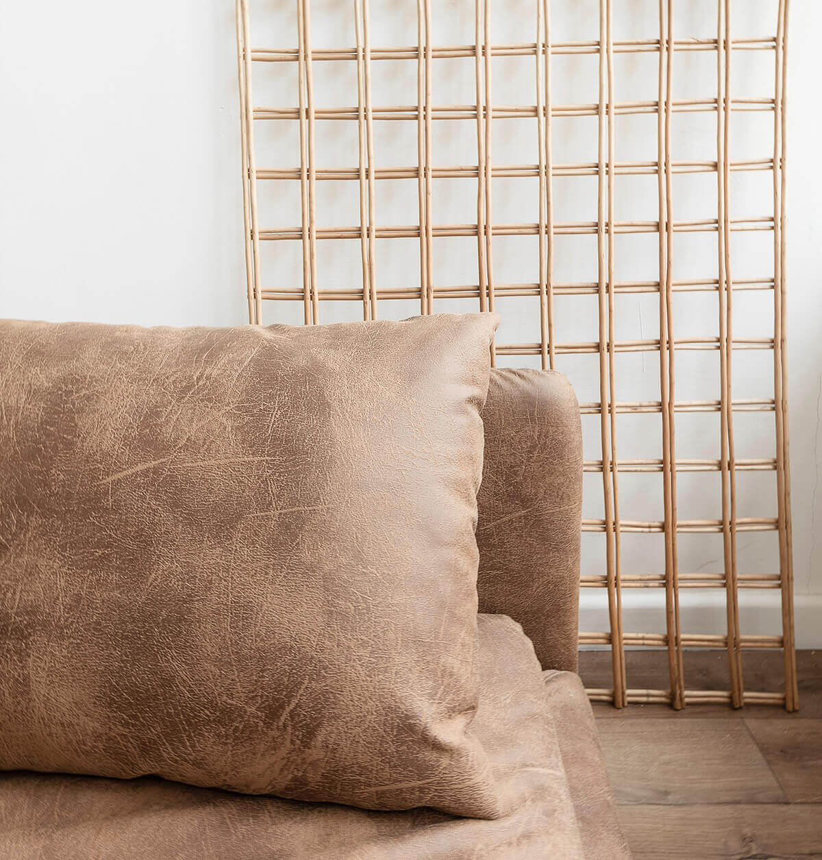 brown leather sofa with wooden lattice decoration on wall